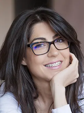 An attractive adult woman with braces smiling because she is getting a straight smile faster with Propel